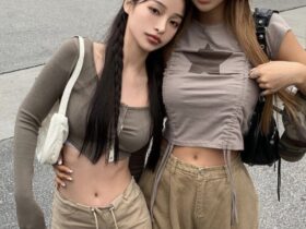 Two Asian women in khaki pants and crop tops embody the Acubi Aesthetic, showcasing a stylish and modern look.