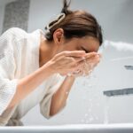 Woman washing her face with water from a faucet