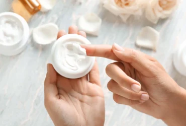 Person applying cream from a jar, showing why people avoid silicone in skin care.